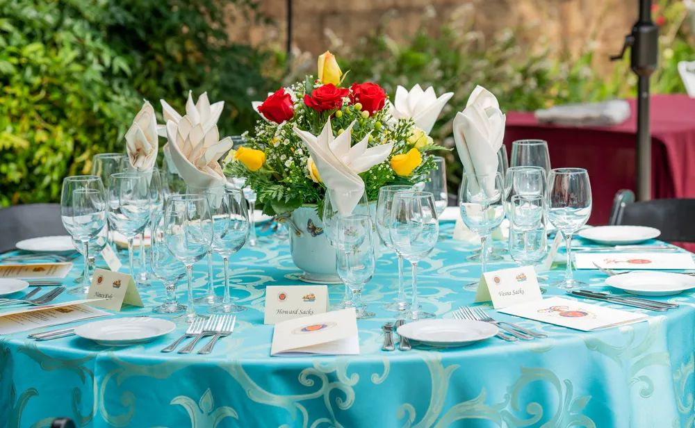 Banquet table set with floral centerpiece, glassware, and place cards
